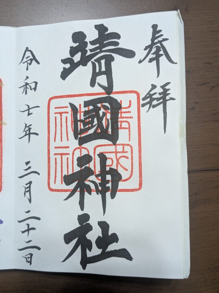 靖國神社御朱印原始照片，中央靖國神社墨書與朱色方印，右側奉拜、左側令和七年三月日期